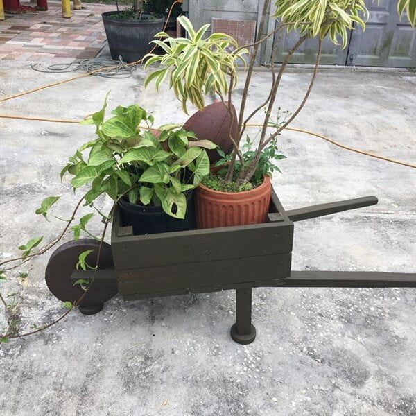 A Small Wooden Wheelbarrow with Plant Vases