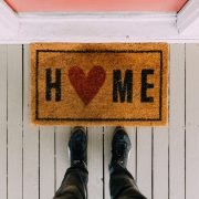 A person's feet on a wooden surface with a sign on it Description automatically generated with low confidence