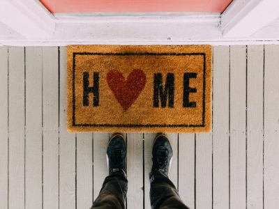 A person's feet on a wooden surface with a sign on it Description automatically generated with low confidence