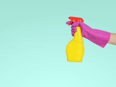 person holding yellow plastic spray bottle