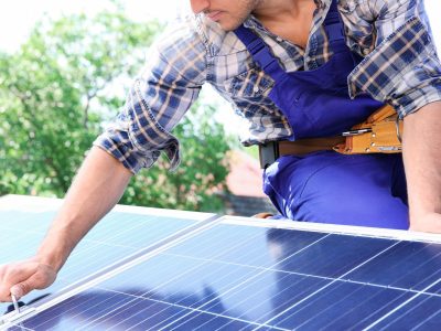 Worker Installing Solar Panels Outdoors