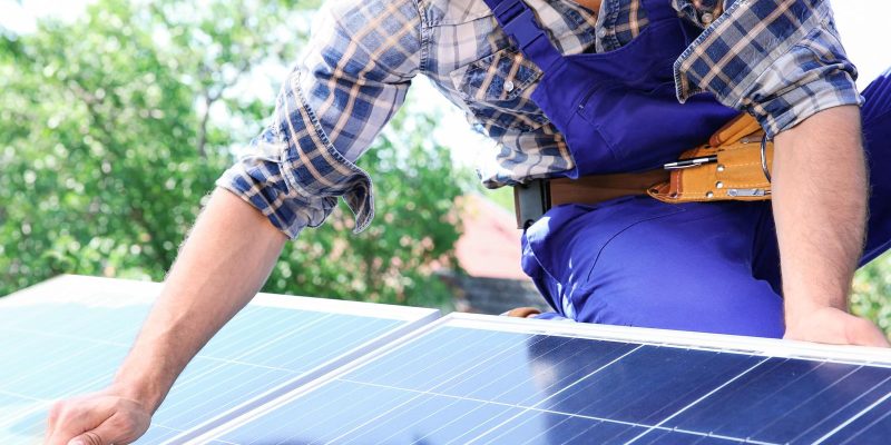 Worker Installing Solar Panels Outdoors