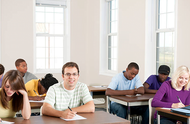 A group of people sitting at desks in a classroom Description automatically generated with medium confidence