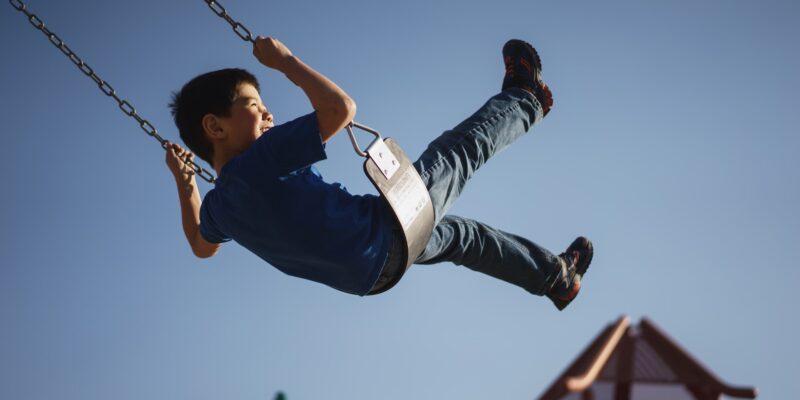 A kid playing happily thanks to your efforts to childproof your yard and garden