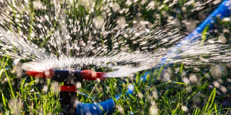 High-efficiency sprinkler watering lush green grass.