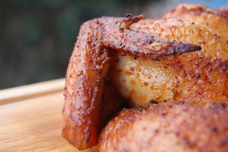 A close-up of a chicken on a wooden cutting board, representing Argentina's love for chicken over beef.