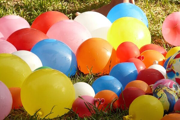 Many colorful balloons scattered on grass