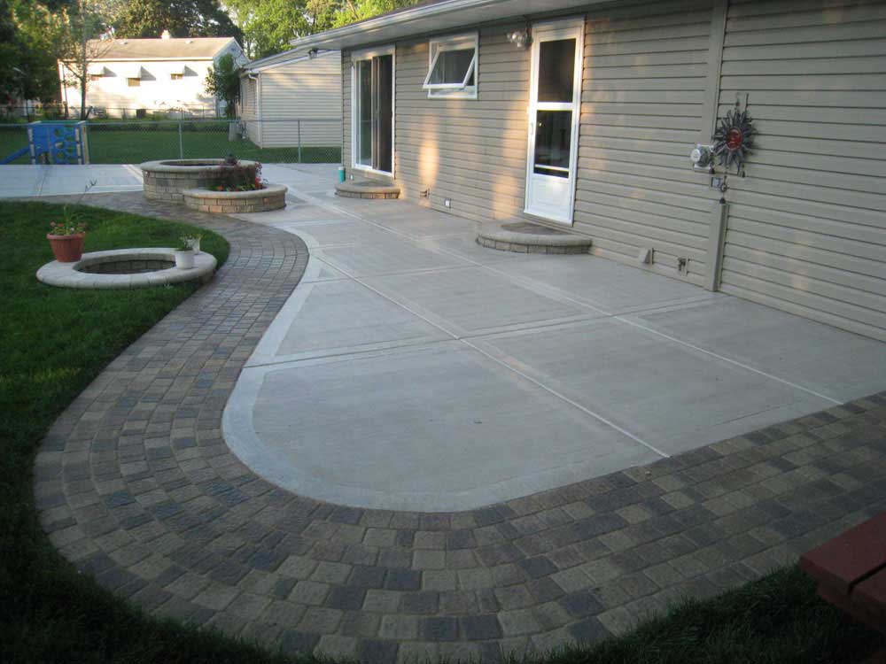 A cozy patio featuring a fire pit and a brick walkway