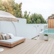 A serene backyard featuring a pool and a white deck