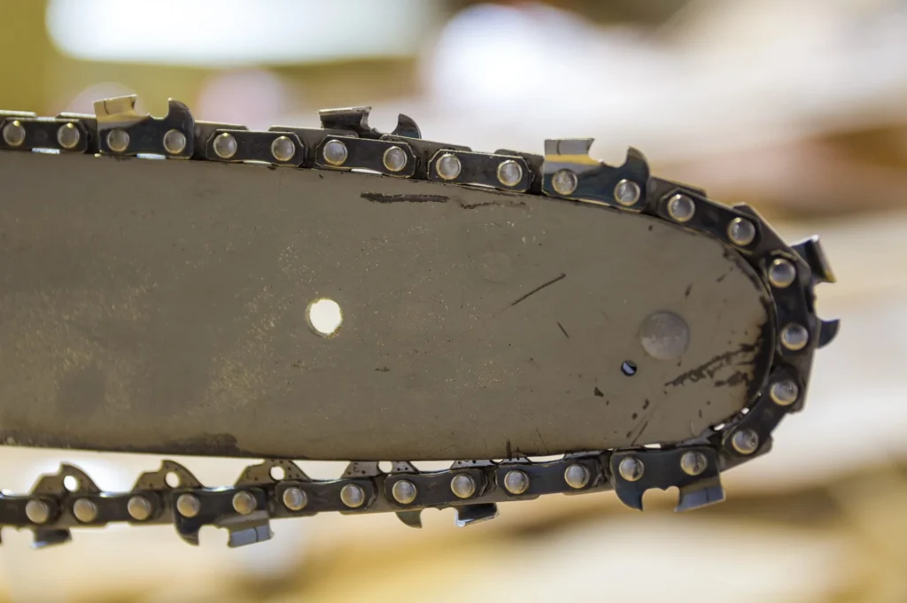 A close-up of a chainsaw with a chain attached. The chainsaw chain should be tight