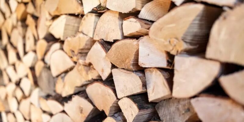 A wall adorned with a stack of logs, potentially firewood in a rick