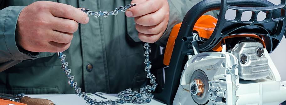 A man holds a chain saw and chain