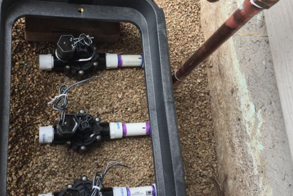 Tools and a cluster of water valves housed within a metal box