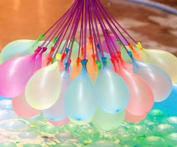 holding colorful balloons in a pool. Enjoying a refreshing dip while surrounded by vibrant balloons.