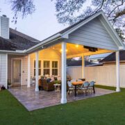 A backyard with a covered patio and a roofed outdoor seating area