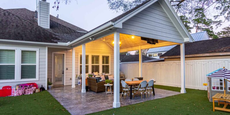 A backyard with a covered patio and a roofed outdoor seating area