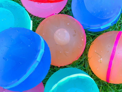 Colorful plastic balls on grass, a fun alternative to water balloons for outdoor activities