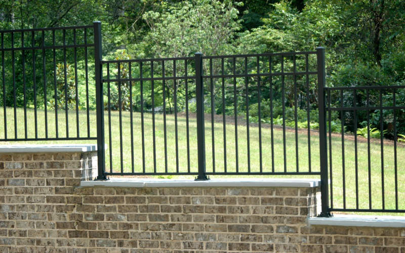 A brick wall with a fence and another brick wall. Guaranteed work.